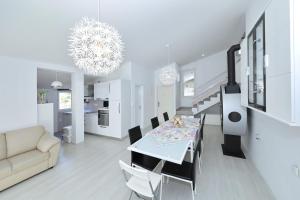 uma sala de estar branca com uma mesa de jantar e um sofá em Apartment with private pool em Sukošan