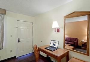 a room with a desk with a laptop on it at Rodeway Inn in Canton