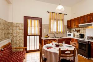 a kitchen with a table and chairs and a kitchen with a stove at Falassarna House in Plátanos