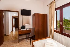 a bedroom with a desk with a laptop and a computer at Falassarna House in Plátanos
