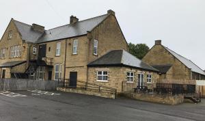 a large brick building with a parking lot in front of it at The Portland in Ashington