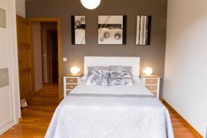 a bedroom with a white bed with two night stands at Apartamento El Arce in Foz