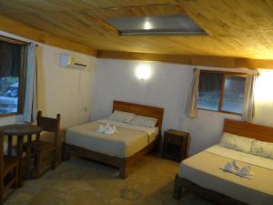 1 dormitorio con 2 camas, mesa y silla en Tres Lagunas, Selva Lacandona, en Lacanjá