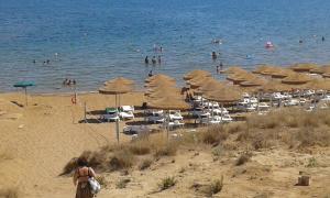 a beach with umbrellas and people swimming in the water at Villa Ida in Capo Rizzuto