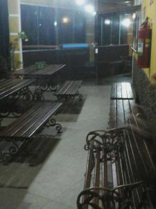 a room with benches and tables in a building at Ilhabela Tênis Clube in Ilhabela