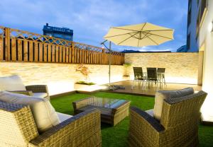 a patio with chairs and a table and an umbrella at Apartamento El Arce in Foz