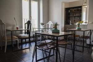 a dining room with tables and chairs and a kitchen at Ziolì in Noto