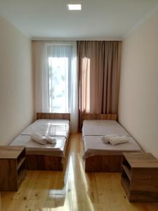 two beds in a room with a window at Eka's guest house in Mestia