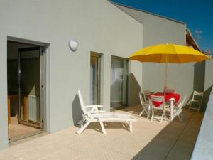 a patio with a table and a yellow umbrella at AS 3 GAIVOTAS in Vila Praia de Âncora