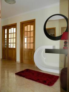 a living room with a mirror and a red rug at AS 3 GAIVOTAS in Vila Praia de Âncora