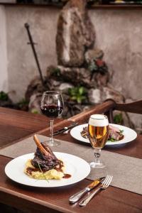 una mesa con dos platos de comida y dos copas de vino en Excalibur Penzion a Restaurace en Moravská Třebová