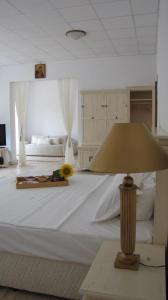 Guest House Ongal في كروشونا: غرفة نوم بيضاء كبيرة مع سرير كبير مع مصباح