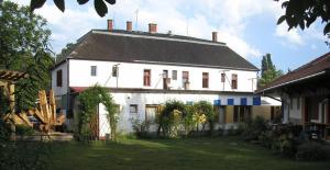 uma grande casa branca com um telhado preto em Hullam Hostel em Révfülöp