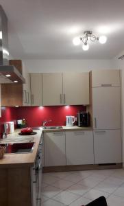 a kitchen with white cabinets and a red wall at Chalet Sunnseitn in Radstadt