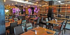 a dining room with wooden tables and chairs at The BlueBell Hotel in Neath