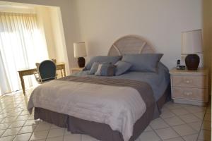 1 dormitorio con 1 cama grande con almohadas azules en Condominios El Dorado II, en Cabo San Lucas
