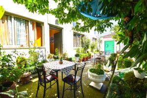 een patio met een tafel met stoelen en potplanten bij Pemaj Hostel in Shkodër