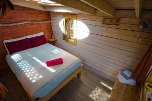 a bedroom with a bed in a wooden cabin at Canopée Lit in Sacré-Coeur-Saguenay