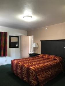 
a hotel room with a bed and a lamp at Townhouse Motel in Weed
