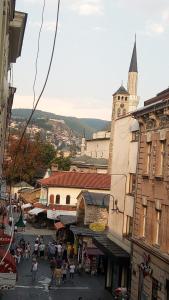 um grupo de pessoas em pé em uma rua com uma igreja em Ferhadija Apartment em Sarajevo