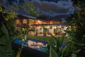 a house with a swimming pool at night at Rukka Lodge in Tumbaco