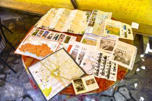 a table with maps and photos on it at Pemaj Hostel in Shkodër