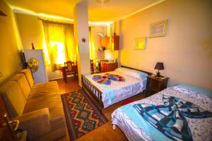 Pemaj Hostel في شكودر: غرفة نوم بها سريرين وغرفة معيشة