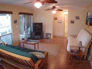 ein Wohnzimmer mit einem Sofa und einem TV in der Unterkunft All Inclusive Waimanalo Beachlots, Sleeps 8 in Waimanalo