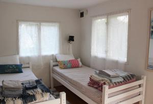 2 Einzelbetten in einem Zimmer mit Fenstern in der Unterkunft Karlsäter - Lilla stugan in Älvkarleby