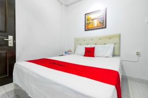 een slaapkamer met een groot wit bed en een rode deken bij Reddoorz near Gajah Mada Plaza 2 in Jakarta