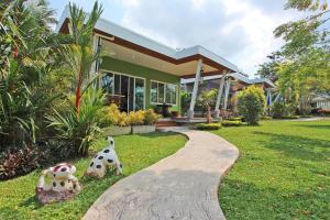 a house with two dalmatians sitting in the grass at Maikhao Home Garden Bungalow in Mai Khao Beach
