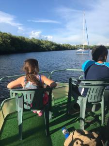 un hombre y una chica sentados en un barco en el agua en Puerto Barillas, en Bahia de Jiquilisco
