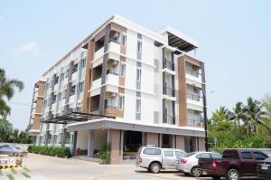 a building with cars parked in a parking lot at Paru Ville in Nakhon Ratchasima