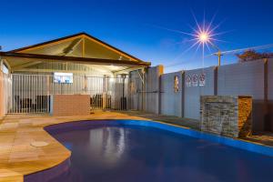 a swimming pool in the backyard of a house at Oasis Motel in Cobar