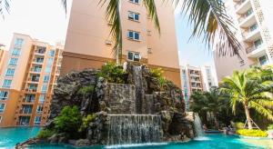 a fountain in the middle of a pool in a resort at Atlantis Condo Resort Jomtien TLH in Jomtien Beach