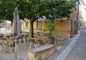 an outdoor cafe with tables and chairs and an umbrella at Chambres d'Hôtes Couleurs du Temps in Périgueux
