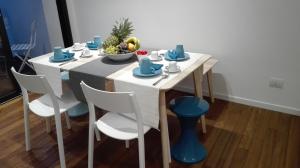 einen weißen Tisch mit Stühlen und eine Obstschale darauf in der Unterkunft B&B Brezza di Mare in Aci Castello