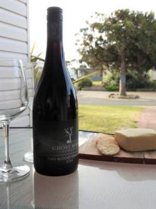 una bottiglia di vino seduta su un tavolo accanto a un bicchiere di Moomba Holiday and Caravan Park a Port Sorell