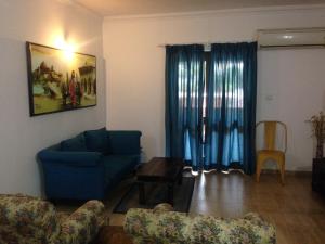 sala de estar con sofá azul y mesa en Pool and Garden Facing Apartment in Riviera Foothills Near Baga, Arpora en Arpora