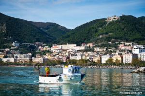 a man in a boat in the water with a city at BebNonnaMaria1928 in Salerno