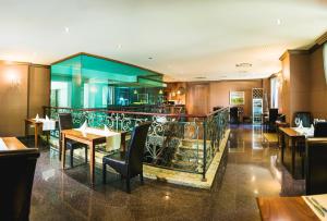 瓦爾納的住宿－文圖拉精品酒店，一间带桌椅和栏杆的餐厅