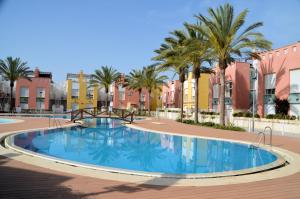 a large swimming pool with palm trees and buildings at Alan Laguna Beach - private jacuzzi on the terrace ALL YEAR in Vera