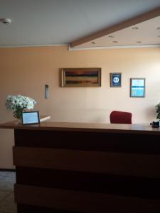 un banco della reception in una sala d'attesa con una sedia rossa di Šolena a Alytus