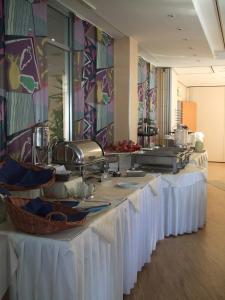 a buffet line with white tables in a restaurant at Sporthotel Wiedenbrueck in Rheda-Wiedenbrück