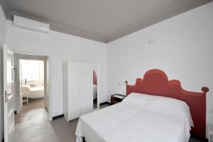 a bedroom with a white bed and a red headboard at B&B Quater Lett in Milan