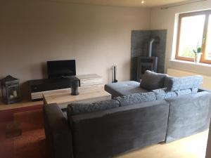 a living room with a couch and a tv at Eifelferienhaus Pruem in Steinmehlen