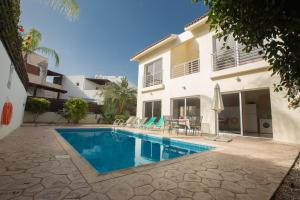 a swimming pool in front of a house at Delfini Villas in Protaras