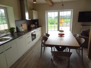 a kitchen with a wooden table and a dining room at Marina Chic in Hasselberg