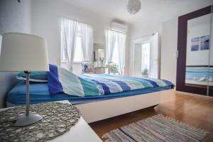 a bedroom with a bed and a table with a lamp at Apartment Dolores in Cres