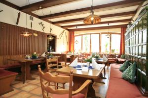 ein Restaurant mit Holztischen, Stühlen und Fenstern in der Unterkunft Rüter's Hotel & Restaurant in Salzhausen
